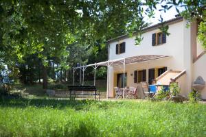 een huis met een picknicktafel en stoelen in de tuin bij Il Casale Di Montefreddo in Sirolo