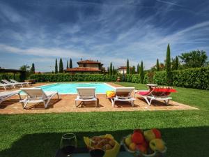 a pool with chairs and a table with fruit on the ground at Luxurious apartment in Lucignano with views in Lucignano