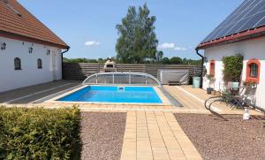 a swimming pool in a yard next to a house at Mariannelund Bed&Beer in Löberöd