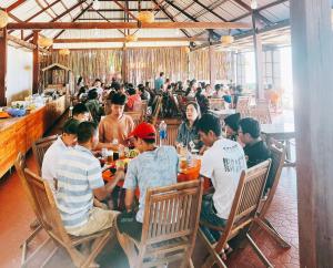 a group of people sitting at a table in a restaurant at Cam Binh Resort Lagi in La Gi