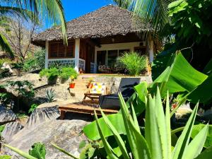 a house with a table and a bench in front of it at COCONUT LODGE KOMBA in Nosy Komba