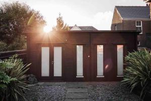 una casa con un garaje con el sol brillando en Summerhouse @ 73 (Forest of Dean) Gloucestershire, en Coleford