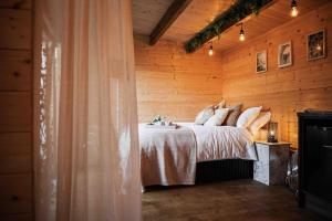 a bedroom with a bed in a wooden wall at Summerhouse @ 73 (Forest of Dean) Gloucestershire in Coleford