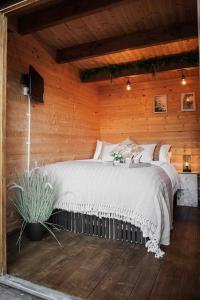 1 dormitorio con 1 cama grande en una pared de madera en Summerhouse @ 73 (Forest of Dean) Gloucestershire, en Coleford