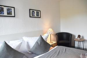 1 dormitorio con 1 cama, 1 silla y 1 lámpara en Hotel Rosenhof Braunlage, en Braunlage
