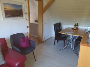 - une salle à manger avec une table, des chaises, une table et des chaises dans l'établissement Fewo-hierundjetzt Lichtenhain am Malerweg, à Lichtenhain