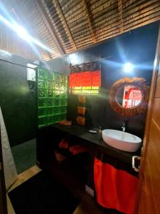 COCONUT LODGE KOMBA في Nosy Komba: حمام مع حوض ومرآة