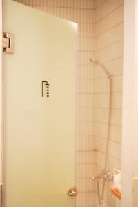 a shower with a glass door in a bathroom at 1986 Cafe & Stay in Hai Phong