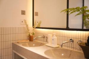 a bathroom with two sinks and a mirror at 1986 Cafe & Stay in Hai Phong