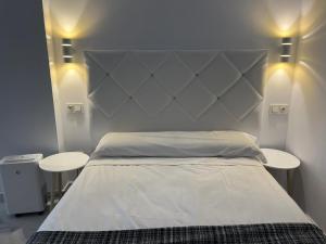 1 dormitorio con 1 cama blanca grande y 2 mesas en Casa Puerta de Almodovar, en Córdoba