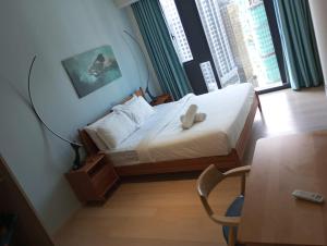 吉隆坡的住宿－Star KLCC By Cozy White，一间卧室配有一张带台灯和桌子的床