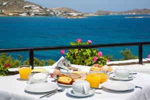 einen Tisch mit einem Frühstück mit Eiern, Brot und Orangensaft in der Unterkunft Hippocampus Hotel in Naoussa