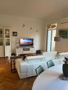 a living room with white furniture and a flat screen tv at Coeur de Marseille in Marseille