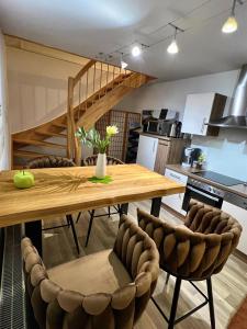 stay!apart Gieckau في ناومبورغ: مطبخ وغرفة طعام مع طاولة وكراسي خشبية