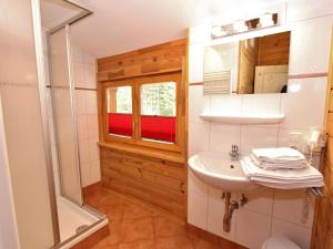 uma casa de banho com um lavatório e um chuveiro em Modern Chalet with Jacuzzi in Krimml em Krimml