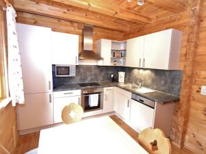 a kitchen with white appliances in a wooden cabin at Modern Chalet with Jacuzzi in Krimml in Krimml