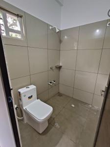 La salle de bains est pourvue de toilettes blanches et d'une fenêtre. dans l'établissement SN Residency, à Kalpatta
