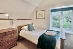 a bedroom with a bed and a window at Stable Corner, a 4 bedroom rural retreat in Loddiswell