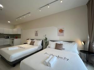 two beds in a hotel room with white sheets at HighPark Suites Kelana Jaya, Petaling Jaya by Sleepy Bear in Petaling Jaya