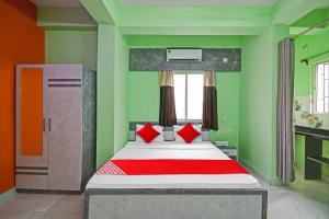 een slaapkamer met een groot bed met groene muren bij Collection O Hotel 7dayz Inn Near City Centre 2 in Calcutta