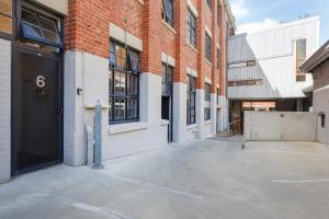 an empty parking lot in front of a brick building at Jarrah Loftprime Location Freo Warehouse in Fremantle