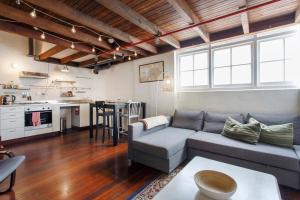 a living room with a couch and a kitchen at Jarrah Loftprime Location Freo Warehouse in Fremantle