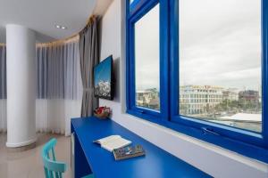 einen blauen Schreibtisch in einem Zimmer mit Fenster in der Unterkunft Lucia Beach Hotel in Đà Nẵng