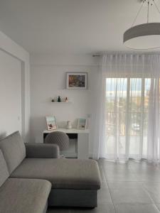 sala de estar blanca con sofá y ventana en Apartamentos La Gaviota, en Roquetas de Mar