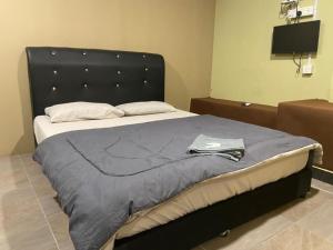 un lit avec une tête de lit noire dans une chambre dans l'établissement Hotel Lii View Labis, à Labis