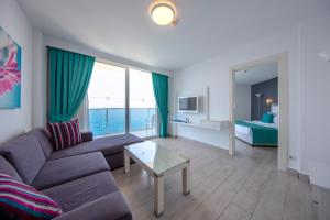 uma sala de estar com um sofá, uma mesa e uma cama em Le Bleu Hotel & Resort Kusadasi em Kusadasi