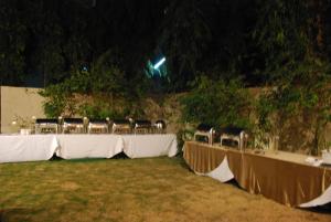 una fila de mesas con sillas en un campo por la noche en Four Points by Sheraton Ahmedabad, en Ahmedabad