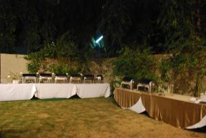 a row of tables with chairs in a field at night at Four Points by Sheraton Ahmedabad in Ahmedabad