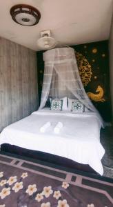 um quarto com uma cama com lençóis brancos e flores no chão em Ou River House em Nongkhiaw