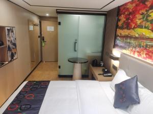ein Hotelzimmer mit einem Bett und einer Glasschiebetür in der Unterkunft Yimimi Apartment - Guangzhou 13th Line Yide Road Metro Station in Guangzhou