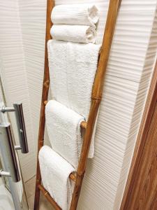 a wooden towel rack with white towels in a bathroom at Closer Place in Tomaszów Mazowiecki