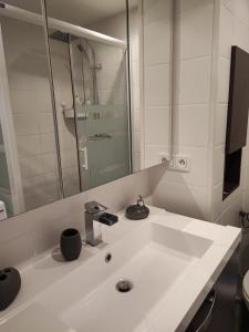 a white bathroom with a sink and a mirror at Studio Cap d'Agde in Cap d'Agde