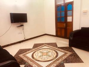 a living room with a television and a rug on the floor at Sawa Sawa Apartment in Ngambo