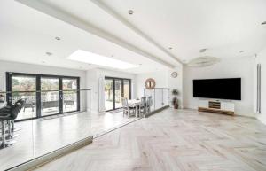 a large living room with a large flat screen tv at Modern Family Home in Greater London in Pinner