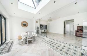 a living room with white walls and a skylight at Modern Family Home in Greater London in Pinner