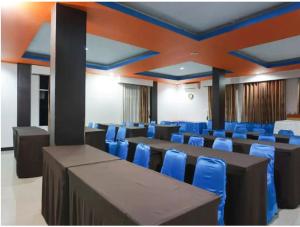STEFANI MAKATI HOTEL في بيكانبارو: قاعة اجتماعات فيها كراسي زرقاء وطاولات
