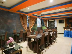 una sala da pranzo con un lungo tavolo e sedie di STEFANI MAKATI HOTEL a Pekanbaru