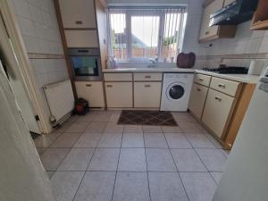 a small kitchen with a washing machine in it at Relax near Wollaton Park in Nottingham