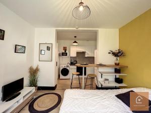 een woonkamer met een bed en een keuken bij Yellow Studio - Arrivée Autonome in Châtellerault