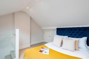Schlafzimmer mit einem großen Bett mit blauem Kopfteil in der Unterkunft ARCORE Premium Apartments Bloomsbury in London