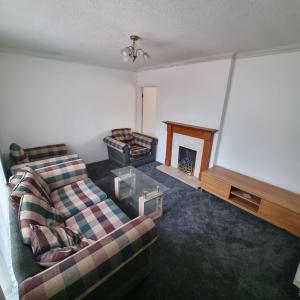 a living room with a couch and a fireplace at Relax near Wollaton Park in Nottingham