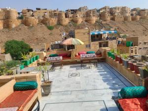 un patio en la azotea con mesas y sillas frente a un castillo en Hotel Oasis Haveli, en Jaisalmer