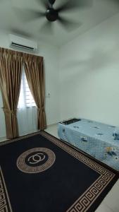 una camera da letto con un tappeto nero sul pavimento di HOMESTAY D'ANGGUN JENDERAM a Kampong Jalan Bahru