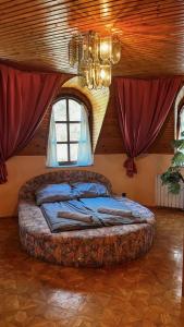 a bedroom with a large bed in a room with windows at Omega Vendégház in Miskolc