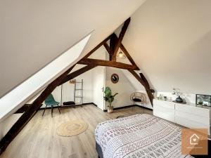 um quarto no sótão com uma cama e piso em madeira em Bienvenue chez Noémie - Arrivée Autonome em Châtellerault