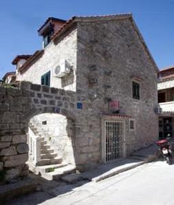 - un grand bâtiment en pierre avec un portail et une porte dans l'établissement Apartments Bepina, à Split